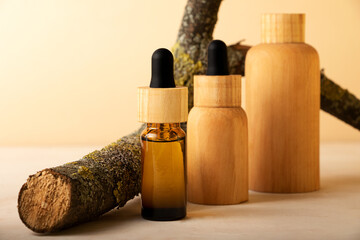 Group of zero waste cosmetics containers with natural tree bark.Beautiful pastel colors,organic products.Isometric beige backgrund with bizarre branch.Concept of the eco friendly manufacturing.