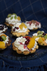 dessert with cream and fruit in tartlets on blue