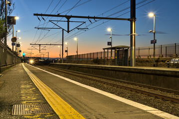 Spectacular view of railway station and colorful sky at Blackrock in the evening, Dublin, Ireland. Lights of the coming train in background