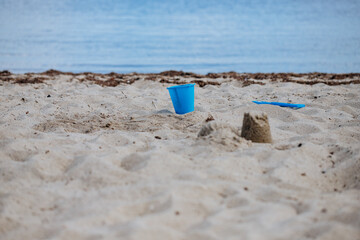 Blue bucket and shovel in the sand on the beach. Children's toys for sand