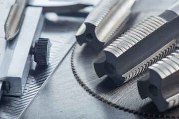 set of different drill bits,thread tap and mill cutters with caliper ruler on steel plate...