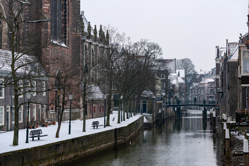 A snowy scene in historic Dordrecht in the Netherlands. Dutch architecture old houses and homes on the canal.
