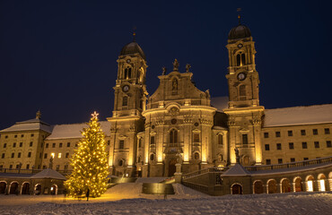 Naklejka na ściany i meble Illuminated swiss abbey of Einsiedeln at blue hour in Christmas winter time