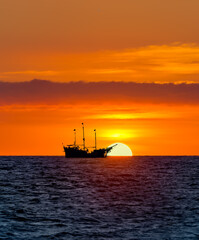 Obraz na płótnie Canvas Ship Sunset Ocean Vertical