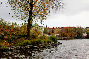 Flowing water of Vlatava river against the city landscape of Prague in autumn