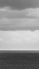 Partial vertical view of the sea on a gray day and photographed in black and white.