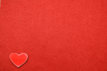 Red heart with the inscription love, on a background of red material
