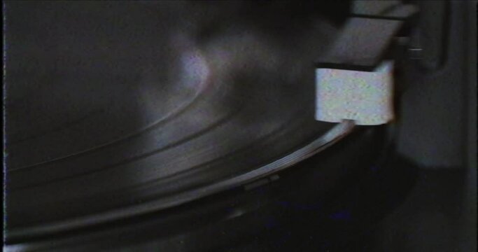 Old vintage vinyl LP player in VHS footage. Playing LP plate with arm in vintage 8mm film. Vinyl plate with needle