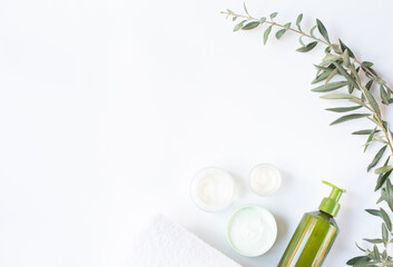 Fototapeta na wymiar Spa and beauty. A set of cosmetics for care. Creams and a sprig of an olive tree are on a white background. Free space for text. 