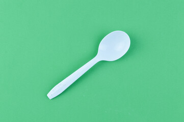 White spoon isolated on a green background.
