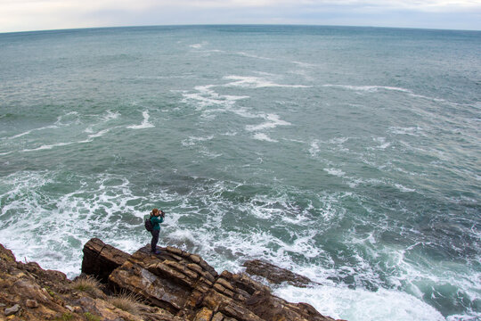 High angle shot of  photographer taking a photo of the stormy ocean