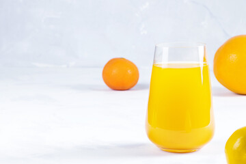 Multifruit juice in glass on white background. Orange jucie.Fresh fruits.Healthy food and drink. Lemons and tangerines.