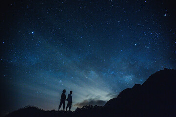 Silhouette of elderly couple on the hill.  Stargazing at Oahu island, Hawaii. Starry night sky, Milky Way galaxy astrophotography. - 403920700