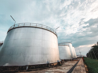 Oil storage tank  In industrial areas.  Crude oil storage plant  For export.  Palm oil factories in Asia. The atmosphere at sunset.  Within the industrial plant