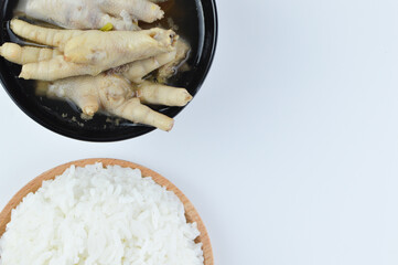 The crop image of white rice and chicken feet spicy soup isolated on a white background. Famous Asian food.