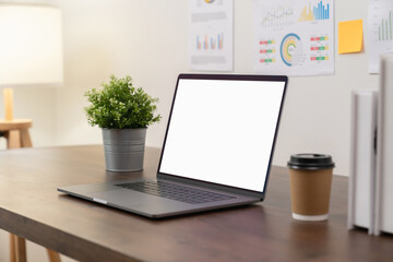 Laptop with blank screen on table in modern office. Mockup of advertisement.