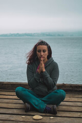 young woman meditating in front of the sea