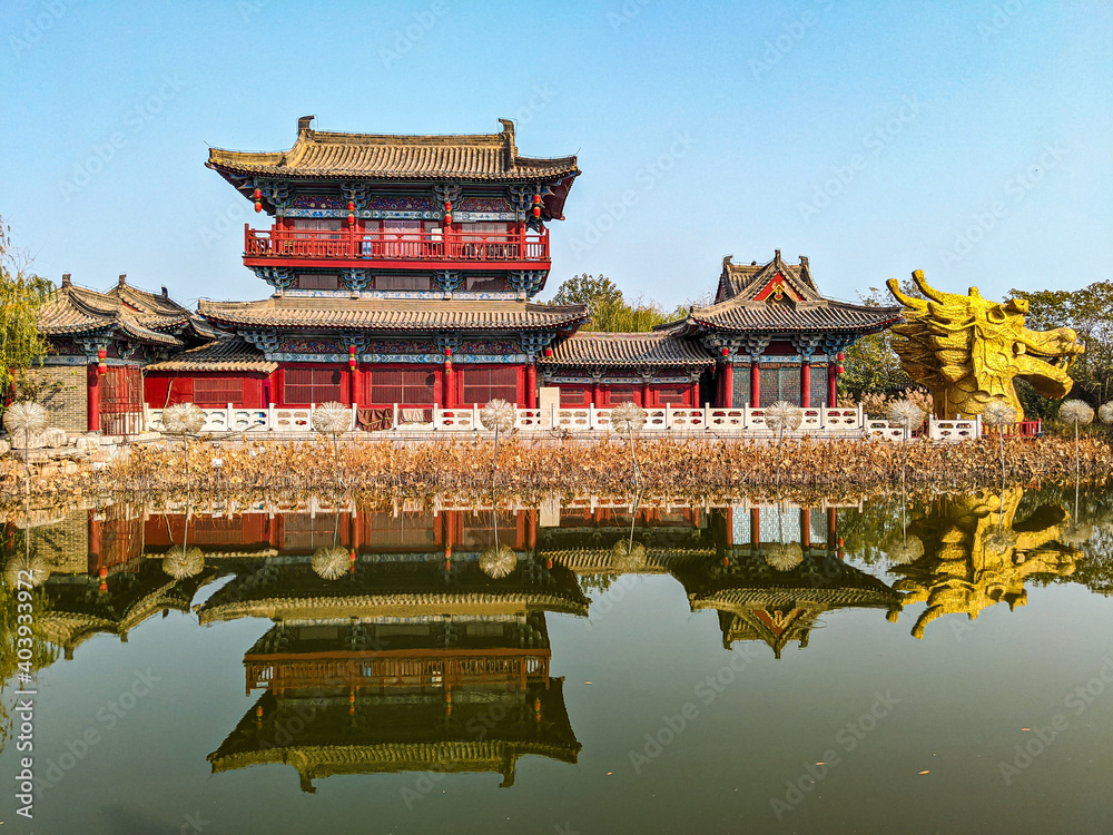 Poster historic buddhist temple with a zen garden reflecting in a lake in china under a bright sky