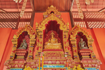 Fototapeta na wymiar Phayao, Thailand - Dec 6, 2020: Low Angle Gold Prajao Tanjai Statue in Sanctuary or Chapel at Wat Analayo Temple with Natural Light