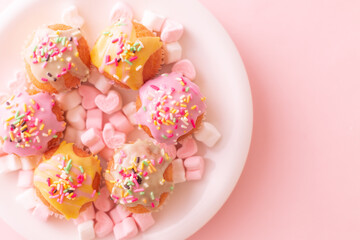 Fototapeta na wymiar small colorful cakes with pink and white heart shaped marshmallows