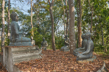 Phayao, Thailand - Dec 6, 2020: Right View of Buddha Statue Giving The First Sermon with 5 Disciples on Forest Backgroud in Wat Analayo Temple
