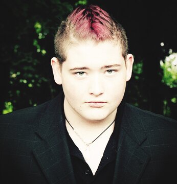 Portrait Of Teenage Boy With Dyed Hair Standing At Park