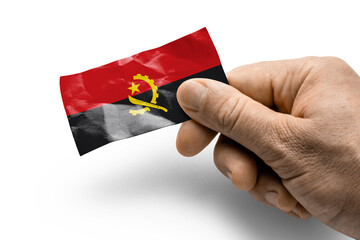 Hand holding a card with a national flag the Angola