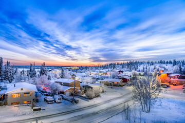 Sunrise over looking neighborhood in Yellowknife during winter with snow, road and clouds  - obrazy, fototapety, plakaty