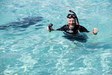 Snorkeling man in shallow ocean water