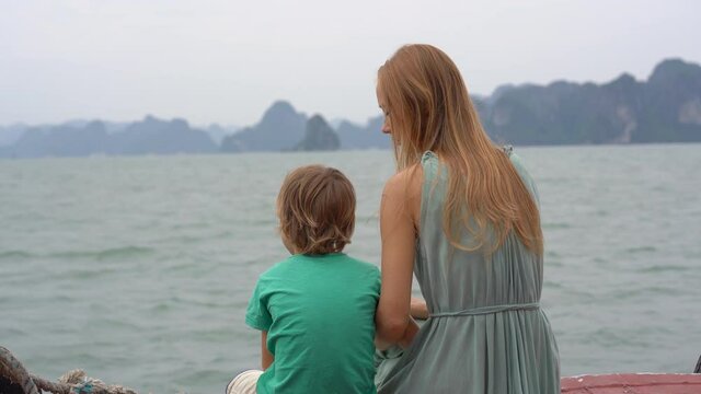 Mother and son tourists visit the Halong Bay national park in Vietnam consisting of thousands of small and big limestone islands. Travel to Vietnam concept