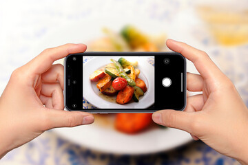 レストランで料理をスマートフォンで撮影しているイメージビジュアル