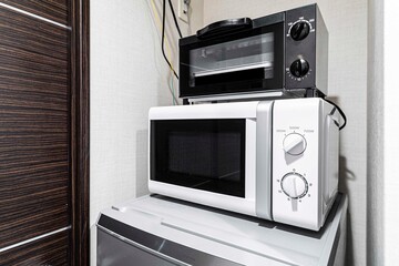 Fototapeta premium Microwave and mini oven on the fridge in the room