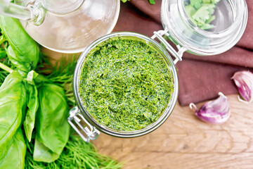 Sauce of spicy greens in jar on board top