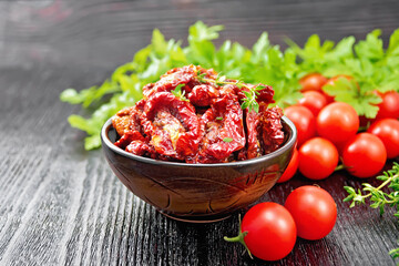 Tomatoes sun-dried in bowl on dark board