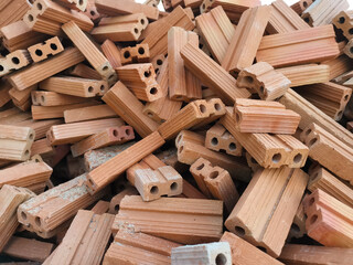Red bricks for construction work. A group of objects placed in a mess.