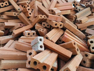 Red bricks for construction work. A group of objects placed in a mess.