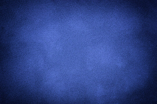 Blue matte background of suede fabric with vignette, closeup. Velvet textile.