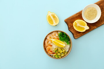 Bowl with tasty rice, shrimps and vegetables on color background