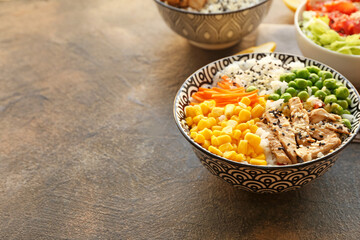 Bowls with tasty rice and vegetables on grunge background