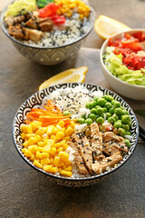 Bowls with tasty rice and vegetables on grunge background