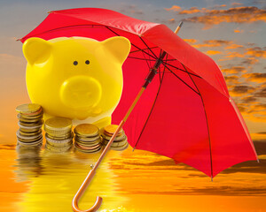 Parapluie rouge protégeant pièces et tirelire cochon jaune , concept épargne 