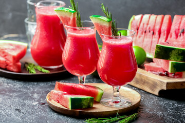 Glasses with fresh watermelon juice on dark background