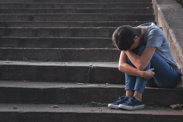 Female junkie sitting on stairs outdoors
