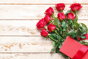 Naklejka na ściany i meble Bouquet of beautiful red roses and blank card on wooden background