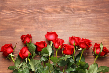Fototapeta na wymiar Beautiful red roses on wooden background