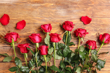 Fototapeta na wymiar Beautiful red roses on wooden background