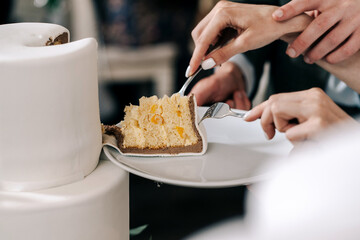 cutting wedding cake bride and groom hands with fork tasting