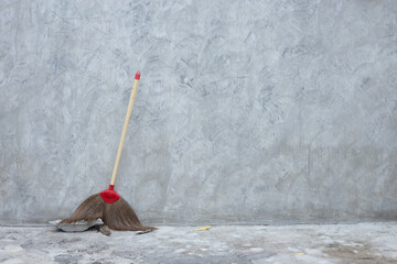 Old broom on grungy concrete wall