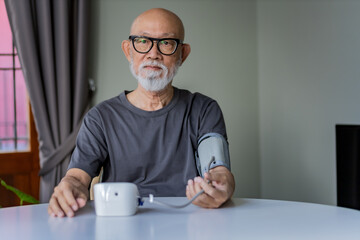 Senior man wear black glasses checking his blood pressure.