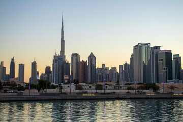 Fototapeta na wymiar Dubai, UAE - 01.08.2021 View of the Dubai city skyline at Dubai Water Canal. Business Bay district. Tallest building in the world Burj Khalifa can be seen in the picture. Outdoors